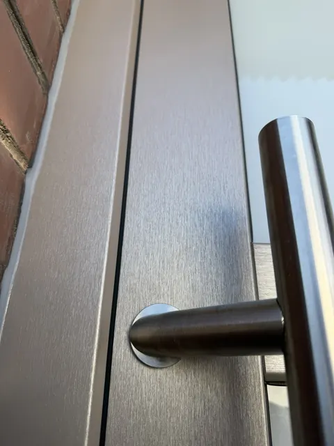 Détail de poignée sur porte d'entrée décor bois